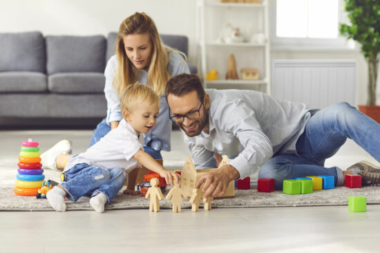 famille jouant au sol dans salon radiateur a inertie en arriere plan